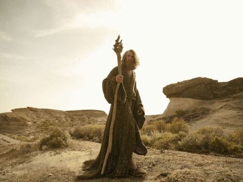 Cena de Gandalf em Os Anéis de Poder, caminhando em uma paisagem desértica na 3ª temporada da série